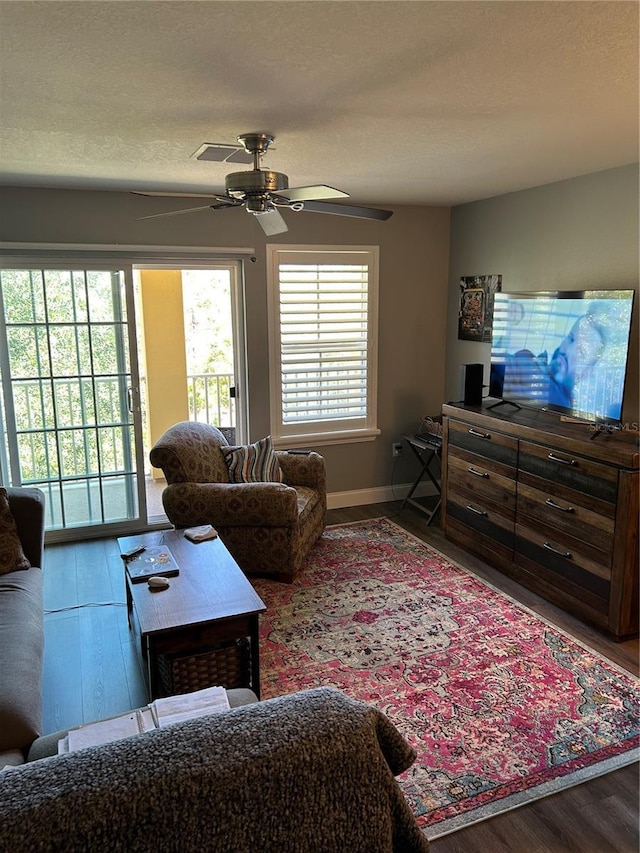 living room featuring a textured ceiling, hardwood / wood-style flooring, and ceiling fan