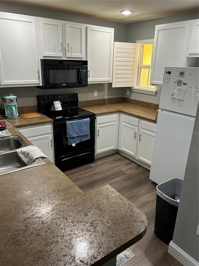 kitchen with dark hardwood / wood-style flooring, white cabinetry, and black appliances