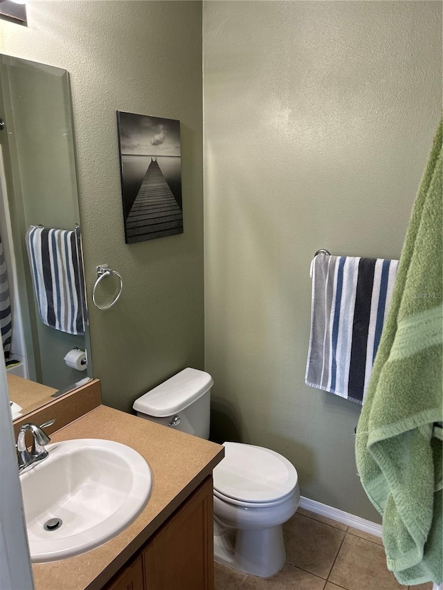 bathroom with tile patterned flooring, vanity, and toilet