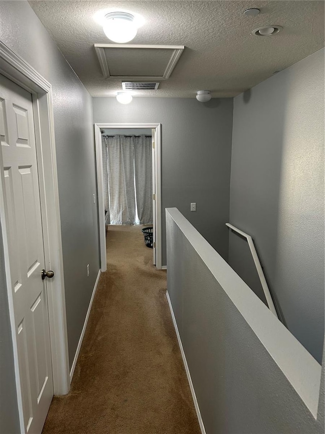 corridor featuring carpet flooring and a textured ceiling