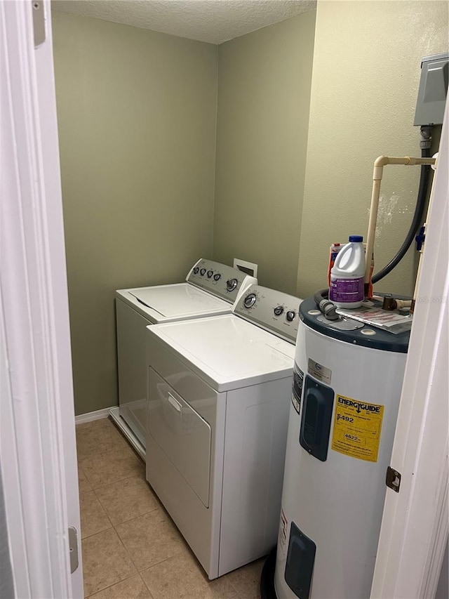 laundry area featuring light tile patterned floors, electric water heater, and separate washer and dryer