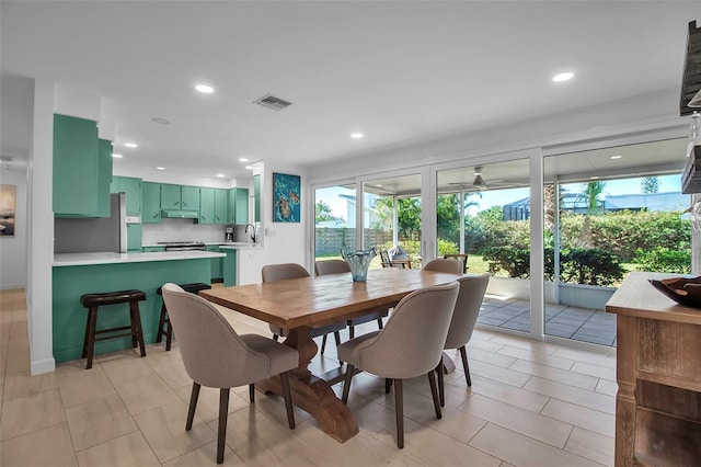 dining area featuring ceiling fan, light tile patterned flooring, sink, and a wealth of natural light