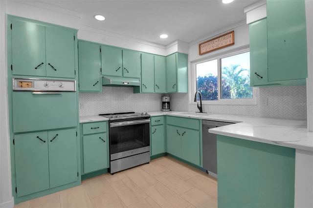 kitchen with tasteful backsplash, sink, stainless steel appliances, and green cabinetry