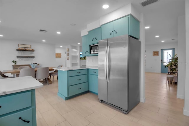 kitchen with kitchen peninsula, decorative backsplash, and stainless steel appliances