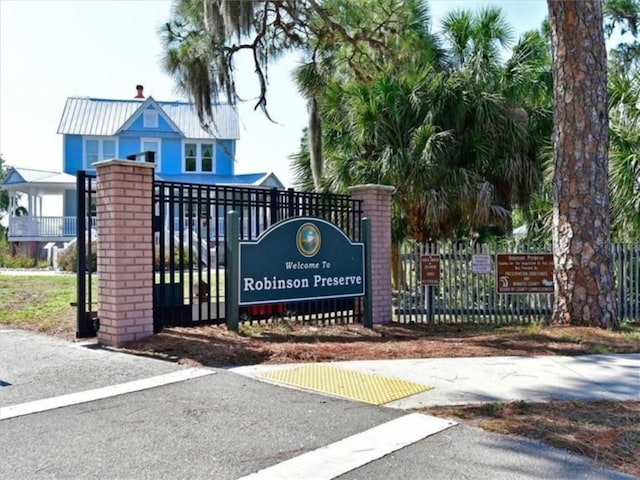 community / neighborhood sign featuring fence