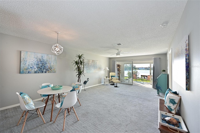 dining room featuring baseboards, visible vents, a ceiling fan, a textured ceiling, and carpet flooring