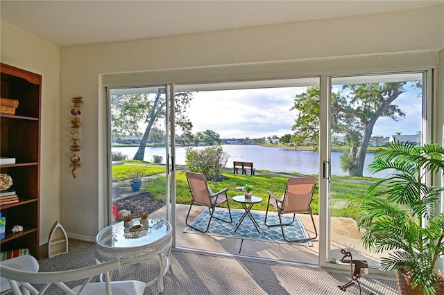 doorway to outside featuring a water view and carpet flooring