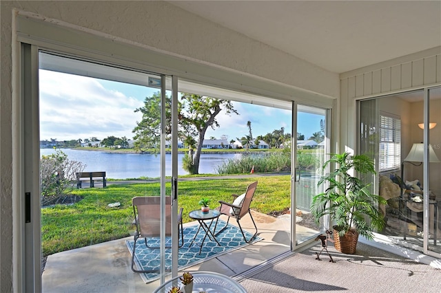 sunroom / solarium featuring a water view