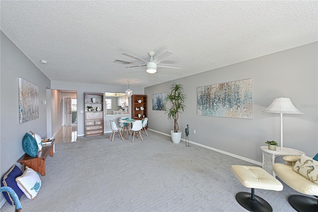 sitting room featuring a textured ceiling, visible vents, a ceiling fan, baseboards, and carpet