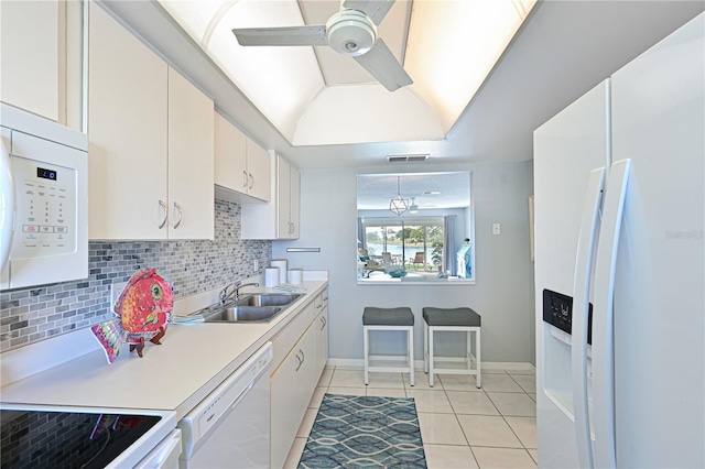 kitchen featuring white appliances, a sink, white cabinetry, light countertops, and backsplash