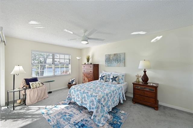 bedroom featuring light carpet, ceiling fan, a textured ceiling, and baseboards