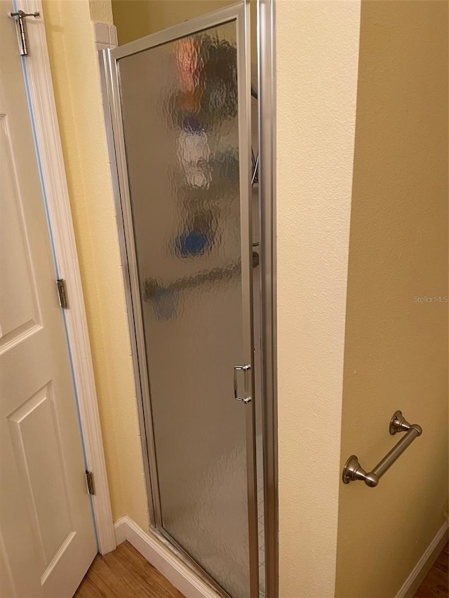 bathroom with wood-type flooring and walk in shower