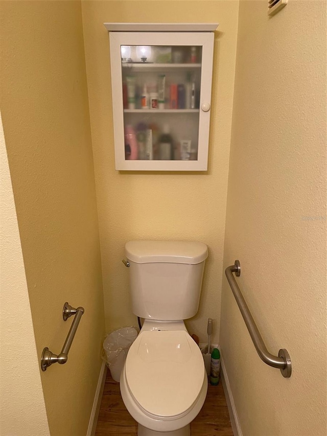 bathroom featuring hardwood / wood-style flooring and toilet