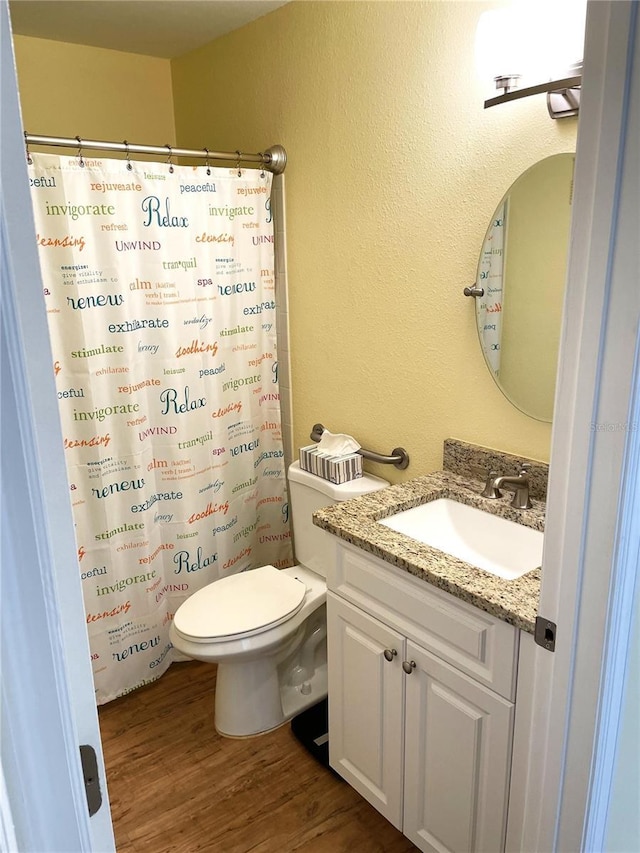 bathroom with vanity, hardwood / wood-style flooring, and toilet