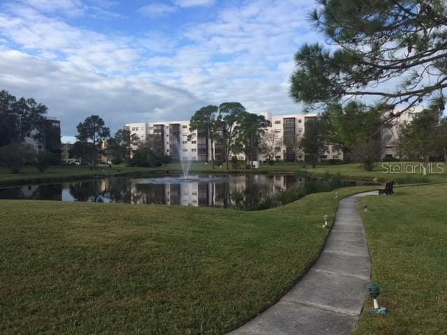 surrounding community with a yard and a water view