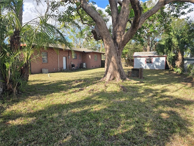 view of yard featuring central air condition unit and a storage unit