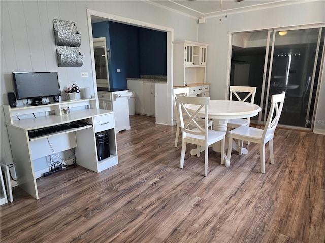 dining area featuring crown molding and dark wood-type flooring