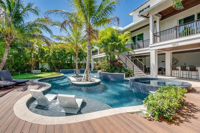 view of swimming pool featuring a bar, pool water feature, and an in ground hot tub