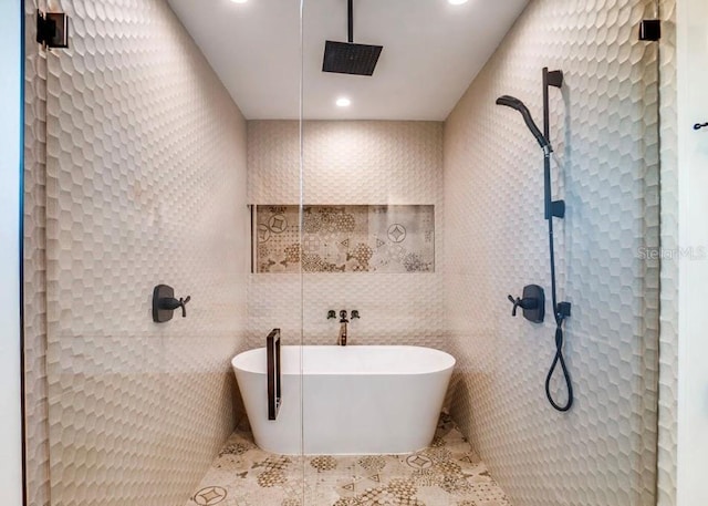 bathroom with independent shower and bath, tile patterned flooring, and tile walls