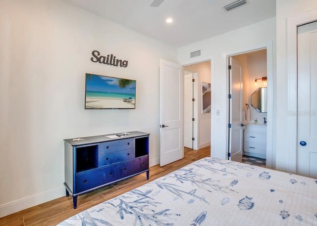 bedroom featuring connected bathroom and hardwood / wood-style flooring