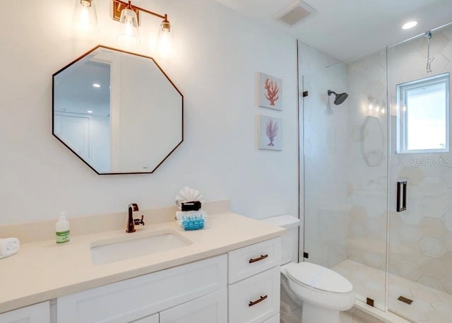 bathroom featuring vanity, an enclosed shower, and toilet