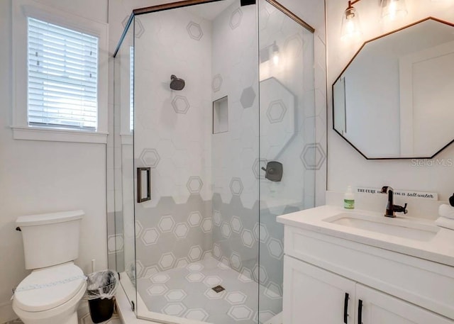 bathroom featuring an enclosed shower, vanity, and toilet