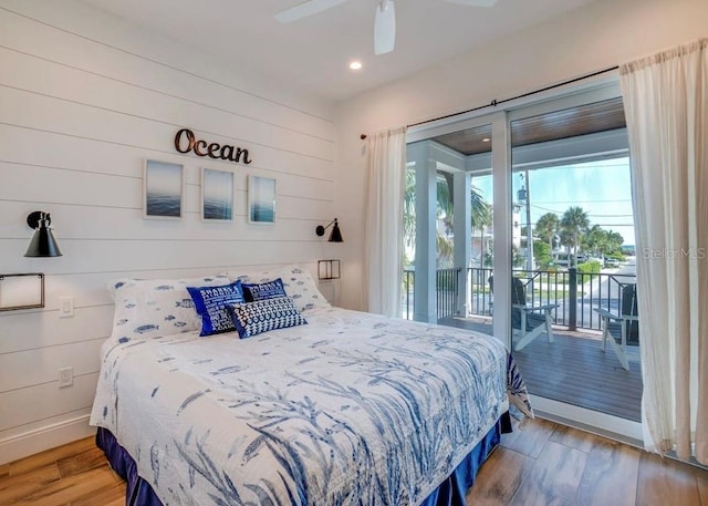 bedroom with ceiling fan, access to exterior, hardwood / wood-style floors, and multiple windows