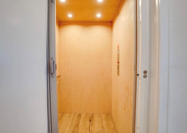 interior details with wood-type flooring, elevator, and wooden ceiling