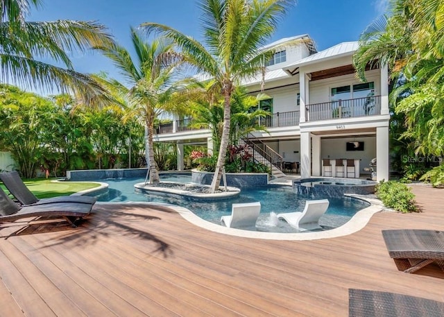 view of swimming pool featuring an in ground hot tub, pool water feature, and a wooden deck