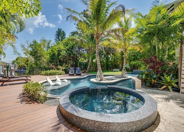 view of swimming pool featuring an in ground hot tub and a deck