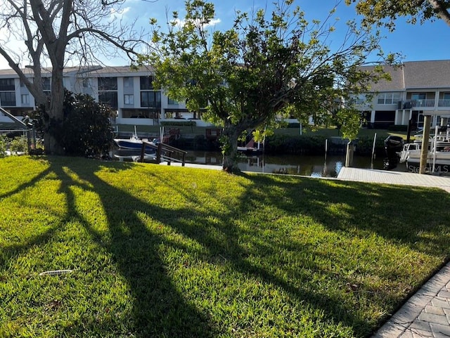 view of yard with a water view and a dock