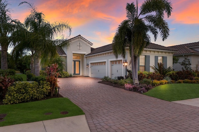 mediterranean / spanish house with a yard and a garage