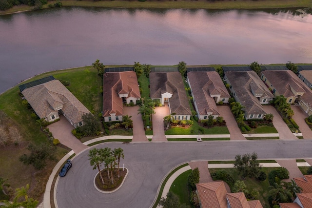 aerial view at dusk featuring a water view