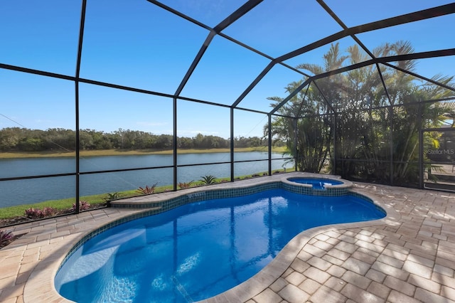 view of pool with glass enclosure, a water view, a patio, and an in ground hot tub