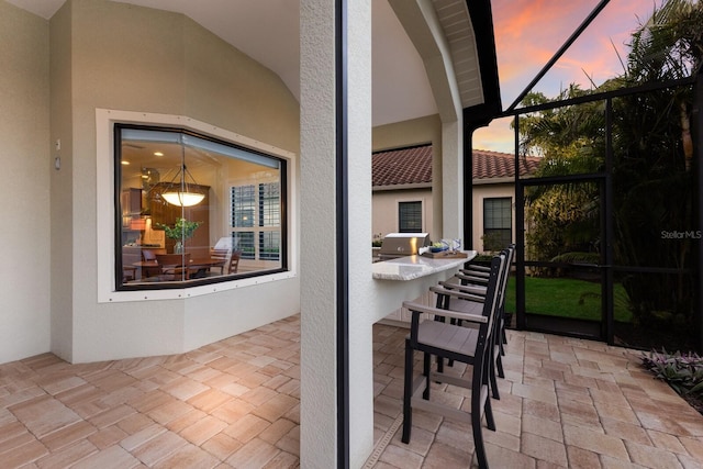 patio terrace at dusk with a lanai and a bar