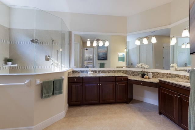 bathroom with a shower, vanity, and tile patterned floors