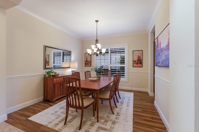 dining space with a chandelier, ornamental molding, and hardwood / wood-style flooring