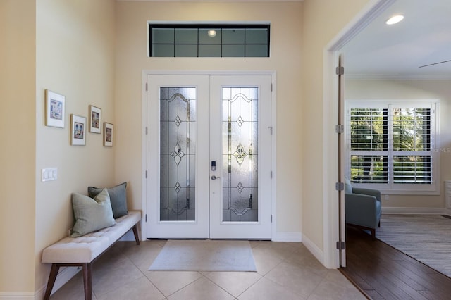 foyer featuring crown molding, french doors, and light tile patterned flooring