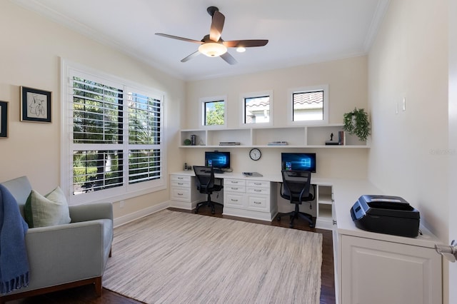 office area featuring crown molding, ceiling fan, dark hardwood / wood-style flooring, and built in desk