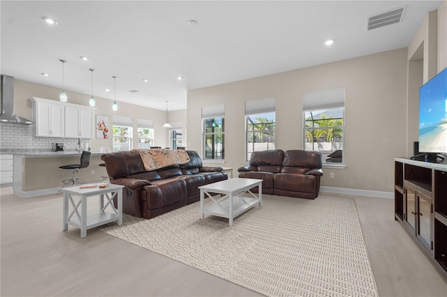 living room featuring a wealth of natural light and light hardwood / wood-style flooring