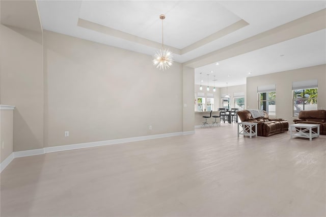 interior space with a raised ceiling and an inviting chandelier