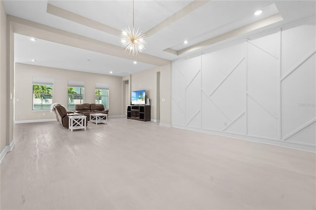 living room with a raised ceiling and a notable chandelier