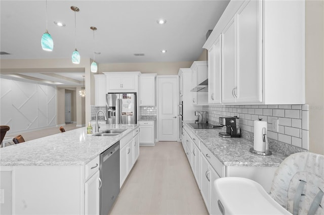 kitchen featuring a breakfast bar, stainless steel appliances, sink, white cabinetry, and hanging light fixtures