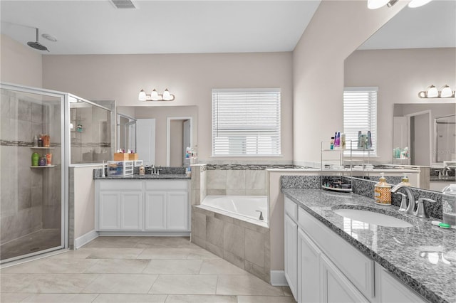 bathroom with tile patterned floors, vanity, and plus walk in shower