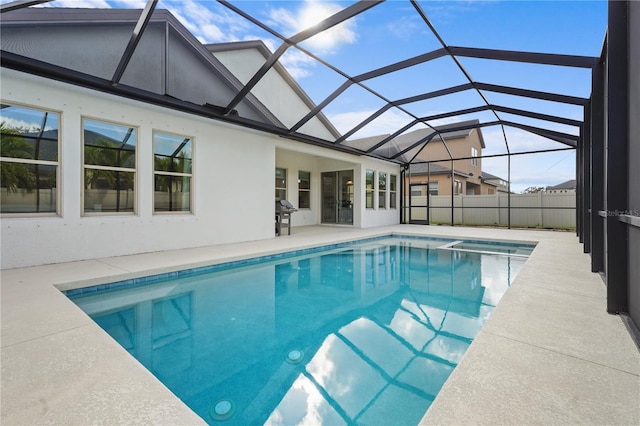 view of swimming pool with glass enclosure, a patio, and grilling area