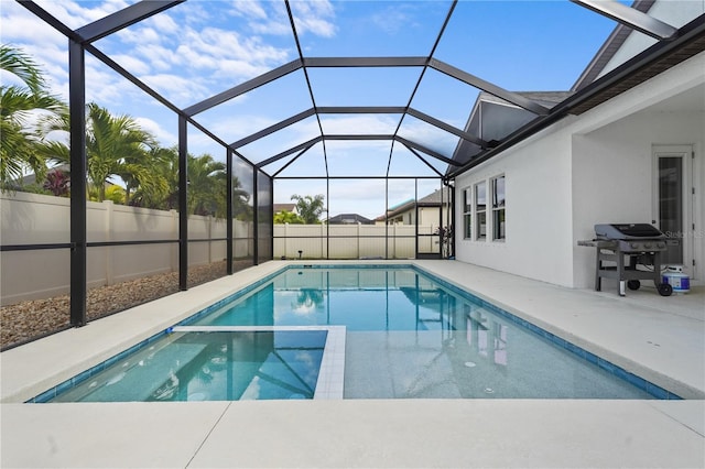 view of swimming pool featuring glass enclosure, a patio, and grilling area