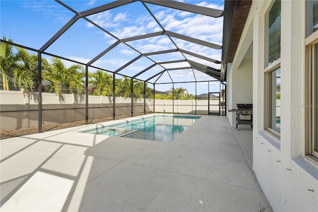 view of swimming pool with glass enclosure and a patio