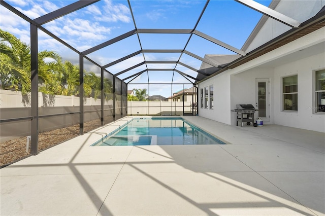 view of pool with area for grilling, a patio, and glass enclosure