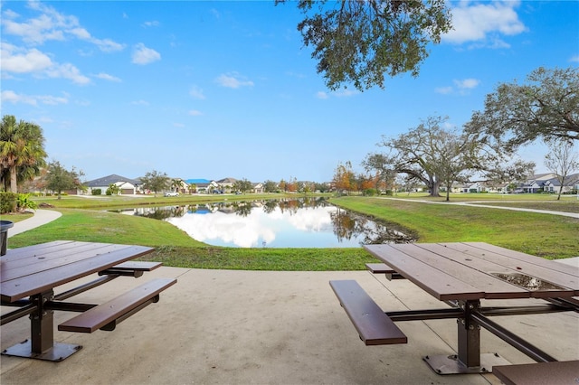 surrounding community with a lawn and a water view