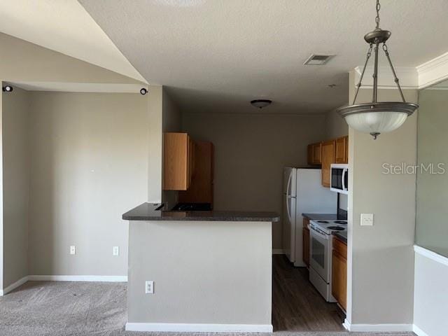 kitchen featuring kitchen peninsula, white appliances, hanging light fixtures, and carpet floors